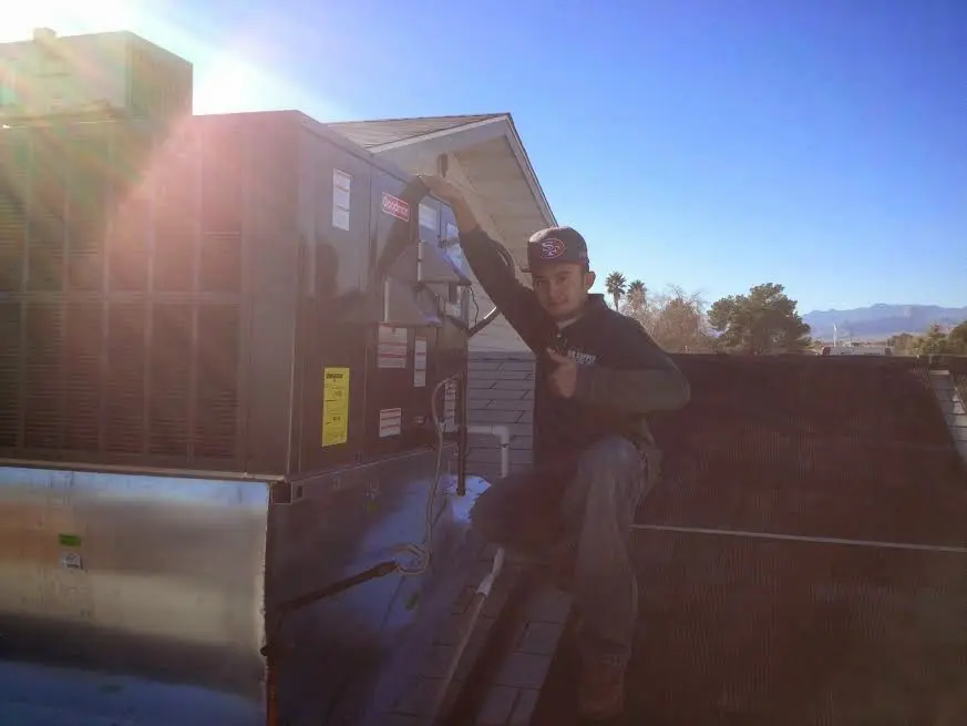 HVAC technician performing Heat Pump Repair on a rooftop unit in Quantico Base